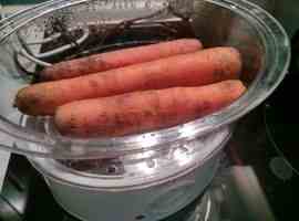 сырая морковь погружена в пароварку